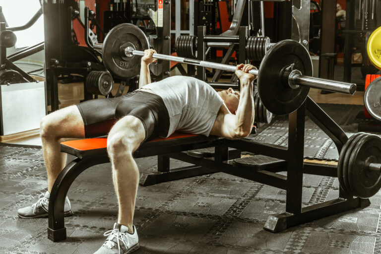 Covek izvodi bench press na klupi